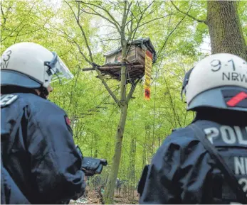  ?? FOTOS: DPA ?? Polizisten haben die ersten Baumhäuser im Hambacher Forst geräumt. Auch eine Aktivistin aus dem Raum Riedlingen haben sie vom Baum herunter geholt.