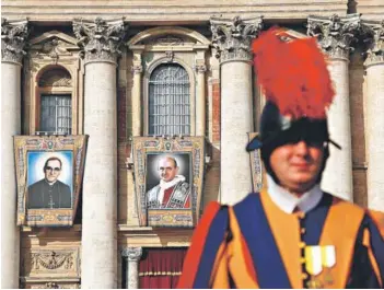  ??  ?? ► Retratos del arzobispo Óscar Arnulfo Romero y el Papa Pablo VI, en las galerías de la basílica de San Pedro, en la Ciudad del Vaticano, ayer.