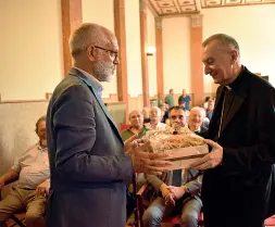  ??  ?? Dono Fabio Comunello (Conca d’oro) porge al cardinale Pietro Parolin un cesto con oggi fatti dai disabili (Pikistudio)