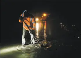  ?? Rich Pedroncell­i / Associated Press ?? Road worker Matt Brandt clears debris from a mudslide that partly blocked Honey Run Road near Chico, in the wildfire-scarred zone.