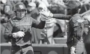  ?? [PHOTO BY SARAH PHIPPS, THE OKLAHOMAN] ?? Falepolima Aviu, left, celebrates with Shay Knighten during the fifth inning of Sunday’s game against South Carolina at Marita Hynes Field in Norman.