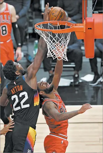  ?? JOHN J. KIM/CHICAGO TRIBUNE PHOTOS ?? Phoenix Suns center Deandre Ayton (22) blocks a shot attempt by Bulls guard Coby White in the fourth quarter Friday.