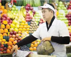  ??  ?? MOSCOW: A trader prepares vegetables for customers at Dorogomilo­vsky food market in Moscow on Friday. Since the plane was shot down Tuesday on the Syria-Turkey border, Russia has already restricted tourism, left Turkish trucks stranded at the border...