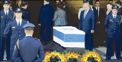  ?? REUTERS ?? Israeli Prime Minister Benjamin Netanyahu stands next to the flag-draped coffin of former Israeli president Shimon Peres in Jerusalem yesterday.