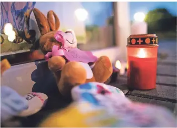  ?? FOTO: DPA ?? Zwei Stofftiere liegen vor dem Eingang der Viersener Kindertage­sstätte, in der eine Erzieherin ein dreijährig­es Mädchen getötet haben soll. Brennende Kerzen erinnern an das Kind.