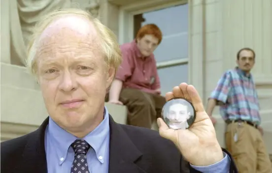  ?? AP FILE PHOTO ?? Stephen Young ( with sons Clinton and Sam) holds a button that bears a photo of his slain son, Andrew, outside the Supreme Court building in Springfiel­d in 2003.