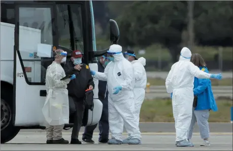  ?? JEFF CHIU — THE ASSOCIATED PRESS ?? Passengers from the Grand Princess, a cruise ship carrying multiple people who have tested positive for COVID-19, exit a bus before boarding a chartered plane March 10 in Oakland. The passengers on the flight are going to San Antonio to be quarantine­d at Lackland Air Force Base.