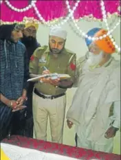  ??  ?? A cop probing the sacrilege at a gurdwara in the Devi Nagar locality of Dera Bassi near Chandigarh on Sunday. HT PHOTO