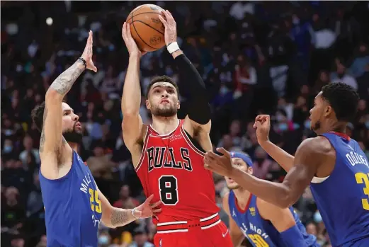  ?? MATTHEW STOCKMAN/GETTY IMAGES ?? Bulls guard Zach LaVine puts up a shot between Nuggets defenders Austin Rivers (left) and P.J. Dozier in the third quarter Friday in Denver.