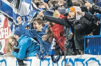 ?? GIOVANNI CAPRIOTTI/MONTREAL GAZETTE ?? Impact fans celebrate after a goal during a 3-0 win over Toronto FC in a MLS playoff game at Saputo Stadium on Thursday.