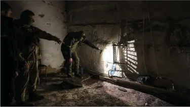  ?? (The New York Times/Lynsey Addario) ?? Members of the Ukrainian security forces inspect a basement used as a prison by occupying Russian forces in Kherson, Ukraine, on Wednesday. Ukrainian officials have opened more than 430 war crime cases from the Kherson region and are investigat­ing four alleged torture sites as well.