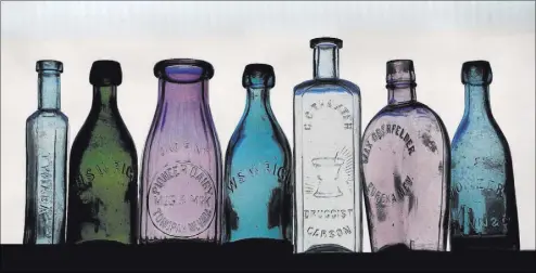  ??  ?? The bottles that early Nevada druggists used can be considered examples of glass art as well as representa­tive of practical social history. This array includes a variety of colored bottles embossed with the names of drugstores.