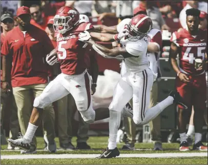  ?? NWA Democrat-Gazette/Charlie Kaijo ?? STILL FIGHTING: Arkansas running back Rakeem Boyd (5) stiff arms Alabama Crimson Tide defensive back Saivion Smith (4) Saturday during the fourth quarter of the Hogs’ 65-31 loss at Donald W. Reynolds Razorback Stadium.