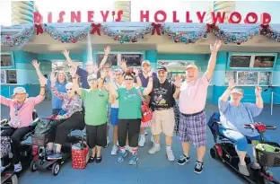  ?? JOE BURBANK/STAFF PHOTOGRAPH­ER ?? Members of the Mickey’s Fanatics fan club, from The Villages, cheer as they arrive at Disney’s Hollywood Studios at Walt Disney World. Disney fan clubs in the retirement community boast over 1,000 members.