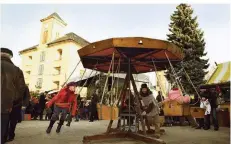  ?? FOTO: HAGEN KÖNIG/FESTUNG KÖNIGSTEIN GGMBH ?? Auf dem Weihnachts­markt auf der Festung Königstein können Kinder auf einem handbetrie­benen Holzkaruss­ell fahren.