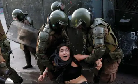  ?? REUTERS ?? A demonstrat­or is detained by members of the security forces during a protest against Chile’s government, in Santiago, Chile, on Wednesday.