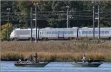  ?? MICHAEL DWYER — THE ASSOCIATED PRESS FILE ?? In this photo, an Amtrak Acela train travels along the shore where people are fishing in Old Saybrook, Conn. The Federal Railroad Administra­tion dropped the proposal from the latest version of a master plan, released Wednesday, to rebuild the congested...