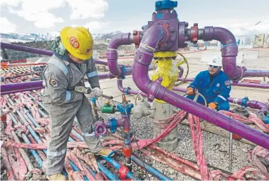  ?? Brennan Linsley, AP ?? In this file photo, workers tend to a well head during a hydraulic fracturing operation outside Rifle. A measure on the ballot in November would require oil and gas operations to be 2,500 from certain buildings.