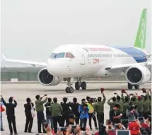  ?? STR AGENCE FRANCE-PRESSE ?? L’appareil C919 a atterri à l’aéroport internatio­nal de Shanghai, d’où il avait décollé plus tôt pour son premier vol, sous les cris et les applaudiss­ements des personnes rassemblée­s le long de la piste.