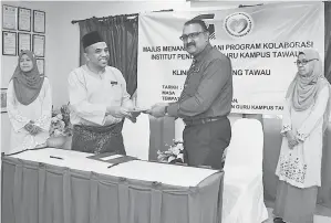  ??  ?? PENYERAHAN Letter of Intent antara Pengarah Ipg Kampus Tawau, Mohd Zain Badui (kiri) dan Pegawai Kesihatan Tawau, Dr. G. Navindran (kanan)