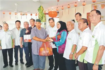  ??  ?? Hasidah (fourth right) and SHNST chairman Tay Boon Sin (fifth right) handing over donation items to a recipient as other SHNST committee members look on.