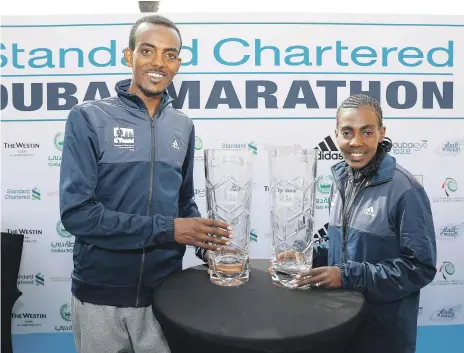  ?? Pawan Singh / The National ?? Tamirat Tola, left, and Worknesh Degefa with the Dubai Marathon trophies that they will be defending
