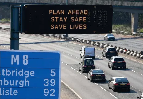  ?? Picture: Gordon Terris ?? M8 traffic yesterday with a sign showing government warnings to ‘Stay Safe’, as new rules mean travel restrictio­ns are lifted