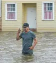  ??  ?? A man wades through storm surge in Mandeville, Louisiana.