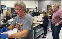  ?? FRANK MECHAM- THE NEWS-HERALD. ?? David Paponetti, left, works in the kitchen alongside his daughters Stephanie Pietropint­o, Melissa Cook, and Tiffany Klinger as Mayor Anthony DiCicco looks on.