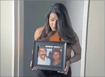  ?? ARIC CRABB — STAFF ARCHIVES ?? Nancy Sanchez holds a picture of her parents, Jose and Alma Sanchez, in June 2020 in San Lorenzo. Her father contracted COVID-19 at Parkview Healthcare Center in Hayward last year and later died at a hospital.