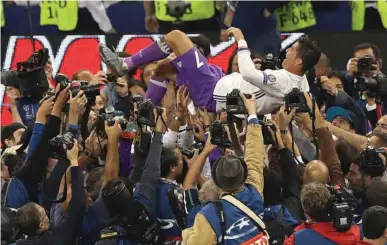  ?? Associated Press ?? Real Madrid's Cristiano Ronaldo is thrown in the air Saturday after the Champions League final soccer match between Juventus and Real Madrid at the Millennium Stadium in Cardiff, Wales. Real Madrid won, 4-1.