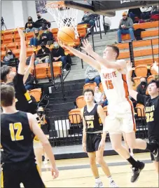  ?? Westside Eagle Observer/MIKE ECKELS ?? Tristan Batie (right) gets past a group of Tigers to shoot a reverse layup during the third quarter.