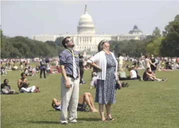  ?? EFE ?? Alegría. Personas observan el eclipse solar desde el National Mall, en Washington D.C.,Estados Unidos, ayer. El acontecimi­ento tardó una hora y media en recorrer el cielo estadounid­ense desde la costa del Pacífico.