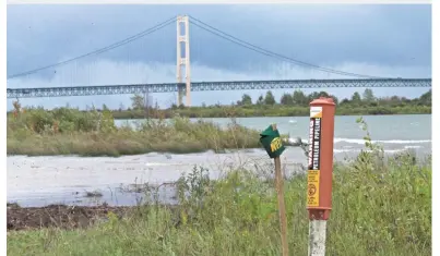  ?? MARK HOFFMAN / MILWAUKEE JOURNAL SENTINEL ?? A marker indicates where an Enbridge oil pipeline enters the north shore of the Straits of Mackinac, as seen in September in St. Ignace, Mich. Two oil pipelines laid in 1953 span the bottom of the Straits.