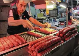  ?? Mai Pham photos ?? Shilin Night Market offers pork sausage and more in a flea-market-style setting.