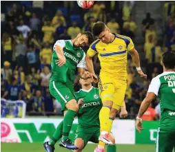  ??  ?? MACCABI TEL AVIV striker Vidar Orn Kjartansso­n (in yellow) netted his team’s opener in last night’s 2-0 win over Maccabi Haifa at Haifa Stadium.