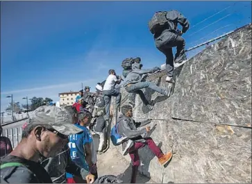  ?? Pedro Pardo AFP/Getty Images ?? CENTRAL AMERICANS climb a fence Sunday in Tijuana to reach the border with the U.S. The number of Central Americans in the U.S. illegally increased as the number of Mexicans declined, a new study found.