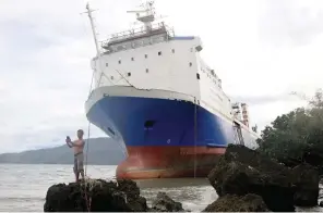  ?? — Reuters ?? A resident takes a selfie in front of a passenger inter-island ferry Shuttle RoRo 5 that was swept ashore at the height of Typhoon Nock-Ten in Mabini, Batangas in the Philippine­s on Monday.