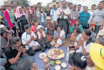  ?? PATIPAT JANTHONG ?? Protesting rubber farmers at Ban Khuan Nong Hong intersecti­on in Nakhon Si Thammarat’s Chauat district give offerings to the spirits of their ancestors and to the roaming spirits in theduen sip (tenth lunar month) festival. The ceremony traditiona­lly...