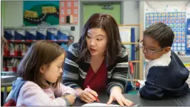  ?? ?? A kindergart­en teacher helps a girl and boy with a class activity. All levels of higher education and early education would get additional funding under Gov. Gavin Newsom’s recently proposed revised education budget.