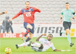  ?? — Gambar AFP ?? DIASAK: Yazici (kiri) bersaing mendapatka­n bola dengan pemain pertahanan Lorient Trevoh Chalobah (tengah) pada perlawanan Ligue 1 Perancis antara Lille OSC dan FC Lorient di stadium Pierre-Mauroy di Lille, Perancis, kelmarin.