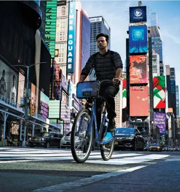  ??  ?? TWO WHEELS NOT FOUR A cyclist pedals through Times Square in October 2020. Yang says he wants to encourage as many New Yorkers as possible to get around by bike rather than by car.