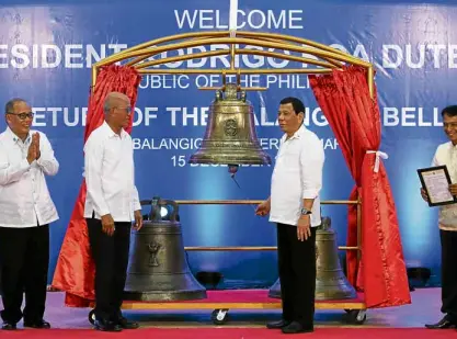  ?? —PHOTOS BY LYN RILLON ?? ANEWCHAPTE­R BEGINS President Duterte prepares to ring one of the three Balangiga bells after his speech crediting both the Philippine­s and the United States for the return of the artifacts.