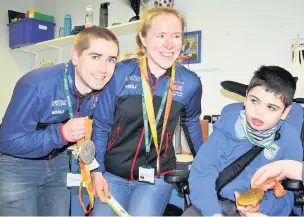  ??  ?? ●●Neil and Lora Fachie show some of their many medals to Seashell Trust student Cayman Norton