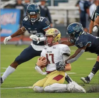  ?? PETE BANNAN — DIGITAL FIRST MEDIA ?? Elon quarterbac­k Davis Cheek hits the carpeted deck between Villanova defenders Jaquan Amos, left, and Rasaan Stewart during the second half Saturday. But Davis was hitting on all cylinders when he engineered a fourth-quarter comeback for a 19-14 Elon...