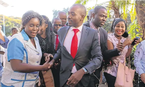  ??  ?? Nelson Chamisa is greeted by supporters during a visit to see victims at a hospital in Harare
