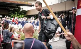  ?? Photograph: Mads Claus Rasmussen/AP ?? Kasper Hjulmand is greeted by flag-waving fans and a marching band as his team leave their hotel in Denmark.