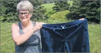  ?? JOE GIBBONS /THE TELEGRAM ?? Kristina Squires holds a pair of pants that fit her three years ago. Back then she weighed 266 pounds. Now, she’s back in shape, 107 pounds lighter and due to run her first Tely 10 Sunday morning.