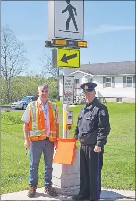  ?? ADAM MACINNIS/THE NEWS ?? Const. Ken MacDonald of the New Glasgow Regional Police and Earl MacKenzie, New Glasgow town engineer, stand by a crosswalk on Vale Road with rectangula­r rapid-flashing beacons.
