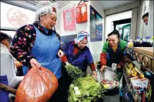  ?? XU YI / XINHUA ?? Farmers traveling to neighborin­g towns sell vegetables on a slowmoving train connecting Yuping, Guizhou province, to the provincial capital of Guiyang on Jan 27.